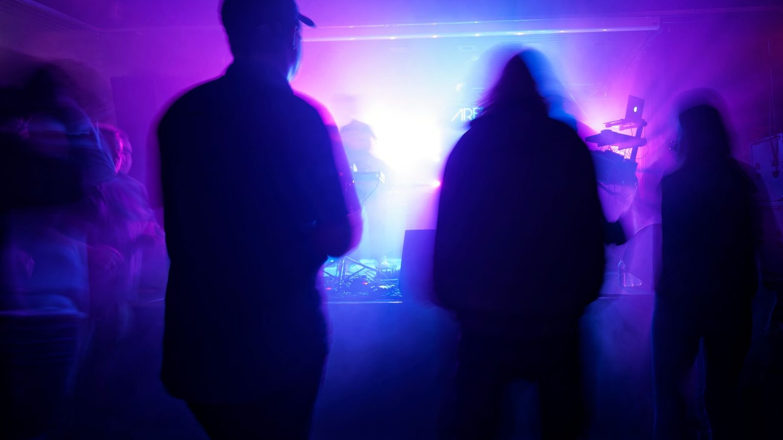 Guests in purple light at an underground Night of Events production