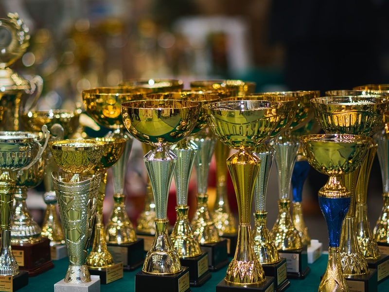 Table of golden trophies before the Best Dressed ceremony