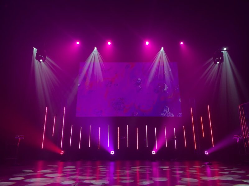 Pink stage beams cutting through haze