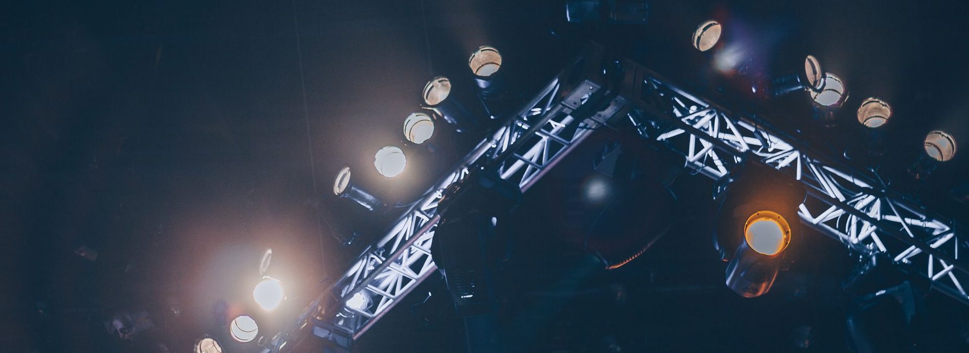Stage lighting rig glowing in a dark venue