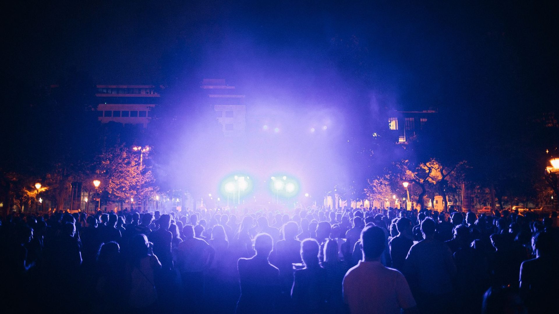 Crowd at a Night of Events evening show under purple stage lights